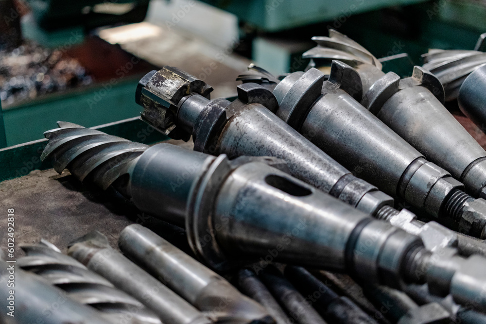 Poster a set of milling cutters on a rack near a lathe. metalworking cutting mills for cnc machines. indust