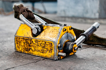 Magnetic gripper for crane. Industrial lifting magnet in a steel structure factory.