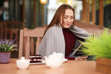 Young girl in cafe sits and drinks tea