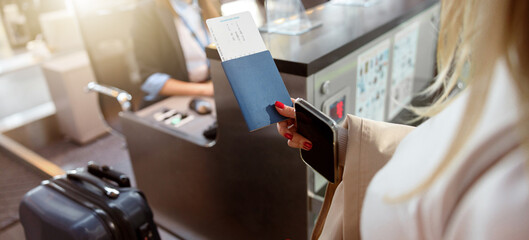 Woman holding passport and tickets near reception desk