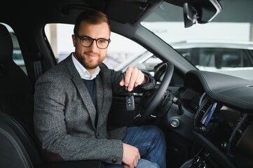 Handsome businessman driving car before buying