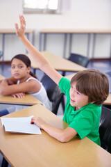 Child raise his hand in school for questions, support and help with classroom education and teaching in school development. Clever boy or kid with arm up for knowledge, learning and answer or advice