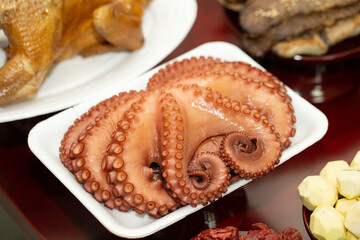 boiled octopus on a plate, prepare food for ancestral rites table	