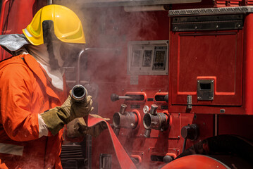 With the fire hoses now ready and the firefighters poised for action they stand prepared to confront the inferno their unwavering determination evident in their focused expressions and steady hands.