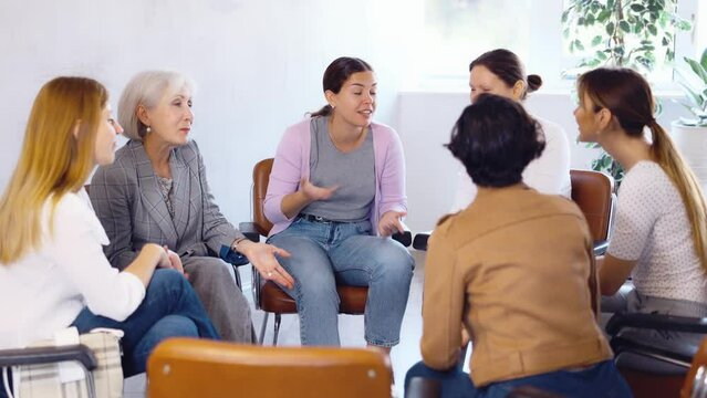 Friendly mixed age group of positive women of different nationalities participating together educational course discussing with interest study topics while sitting 