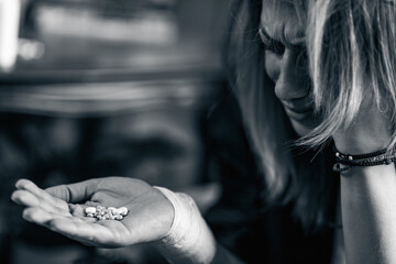 Distressed woman holding pills, mental health concept
