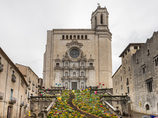 Girona, Spain - May 13th, 2023: TEMPS DE FLORS - Flower Time. View of the steps of the Cathedral with colorful flowers in the Old Town of Girona  on a rainy day. Spring time in Catalonia.