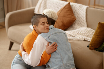 Young lesbian woman couple supporting each other, reconciling after quarrel