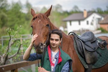 Young boy during the high mounting walking meets a young horse and communicates with it, wild nature, people and animals friendship concept, lifestyle summer outdoor