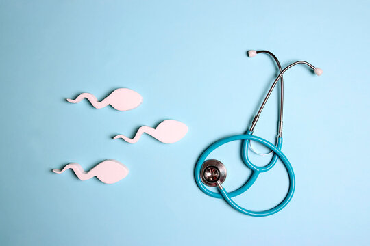 Sperm cells with stethoscope on blue background.