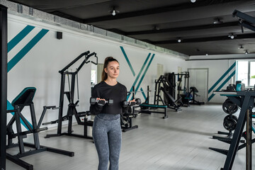 Fototapeta na wymiar fitness girl with a beautiful figure posing in the gym.