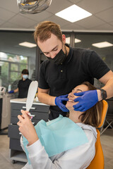 dentist conducts a thorough examination of the patient who came to treat her teeth.