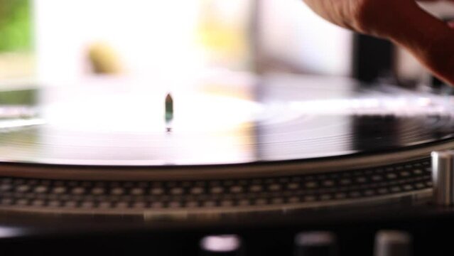 Closeup of headshell of record player going up and stoping