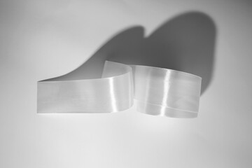 Roll of white textile ribbon. Mockup of roll from satin fabric tape on white background	