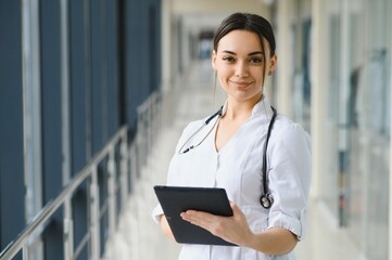 Woman doctor standing with folder at hospital.