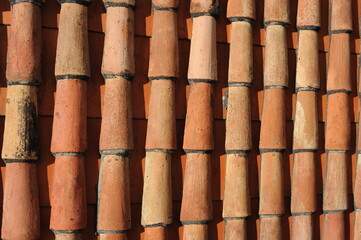 Red and orange roof tiles texture pattern on roof of an old historical building