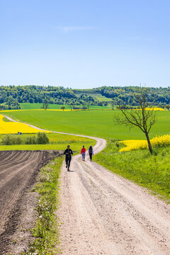 Running woman on a winding dirt road in the countryside