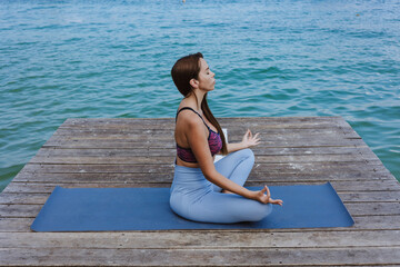 hispanic woman meditating on the beach pier or dock at the seaside in Mexico Latin America, positive people
