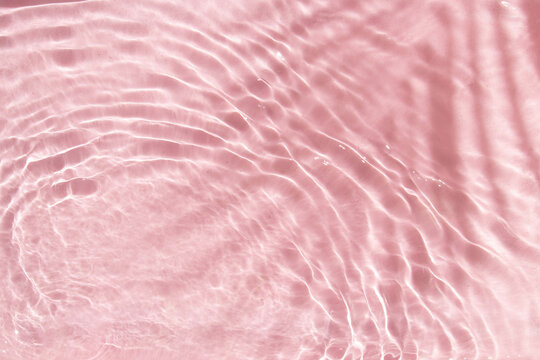 Summer creative layout with palm tree leaf shadow and pastel pink water ripple background. 80s or 90s retro aesthetic fashion idea. Minimal tropical summer idea.