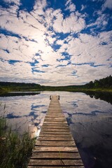 Obraz premium Beautiful summer afternoon landscape by the lake. Charming wooden pier over a small lake in Michala Gora, Poland.