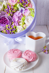 A festive breakfast of pink and white marshmallows, a cup of tea and a box of flowers made from marshmallows