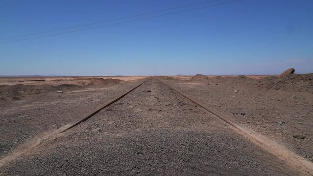 train tracks leading straight to the horizon into nowhere,.