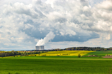 Fototapeta na wymiar A spring landscape with fields, forests, and the Temelin nuclear power station on the horizon.