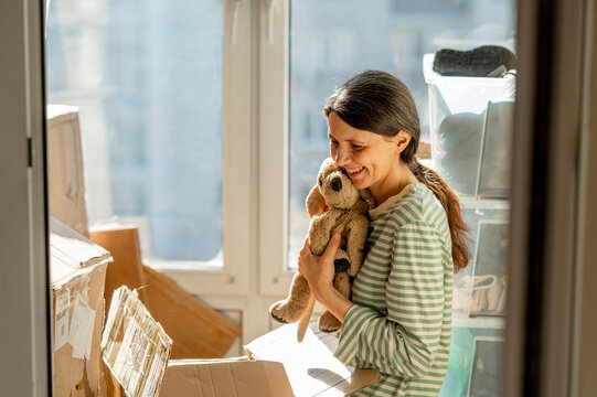 Woman embracing stuffed toy at home