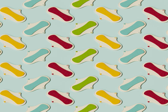 3D pattern of colorful sanitary pads flat laid against green background