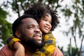 Contemplative girl leaning on father's shoulder