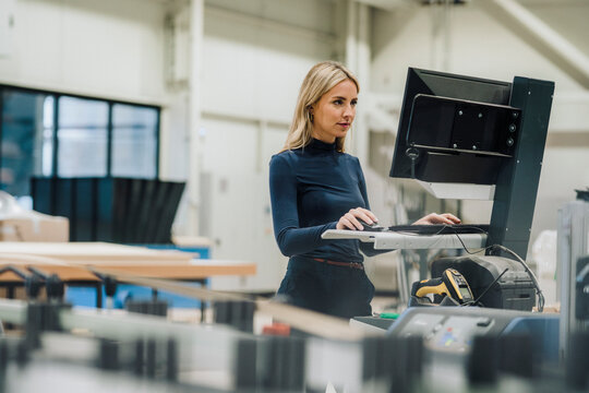 Businesswoman working on desktop PC in carpentry factory