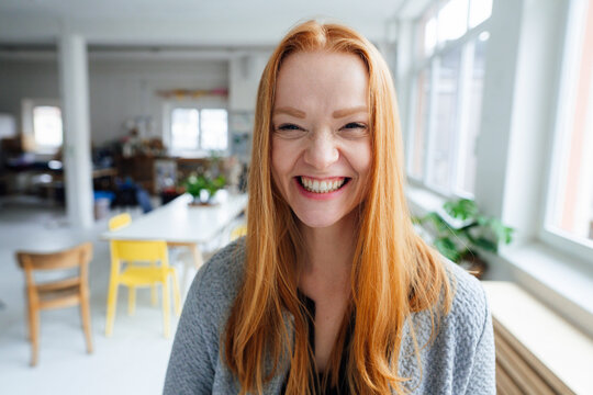 Young happy redhead businesswoman at office - Powered by Adobe