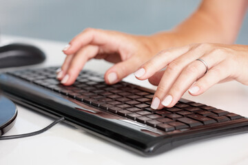 Hands, typing and closeup of business woman on a computer in office for planning, research and email marketing. Keyboard, fingers and person online for management, proposal and review or report