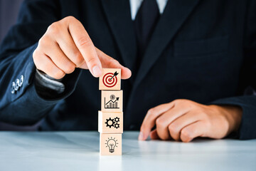 Business strategy planning To market Businessmen arrange wood cubes with goal and target icon, corporate development leadership, success, strategy, business target concept.
