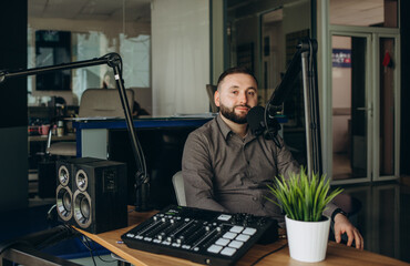 Funny radio presenter or host in radio station studio, portrait of working man