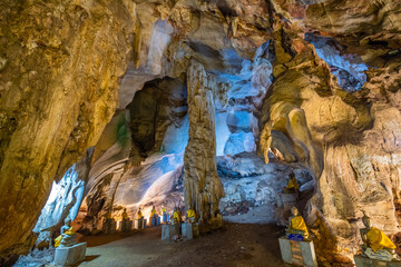 The Buddha statue is situated in a cave with a big pole caused by stalactite and stalagmite at Wat Khao Tham Ma Rong, Bang Saphan, Prachuap Khiri Khan, Thailand