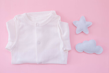 White bodysuit on a pink background. Waiting for the girl. Pregnancy. Clothes for newborns
