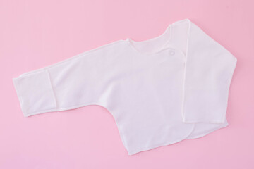 White vest on a pink background. Waiting for the girl. Pregnancy. Clothes for newborns