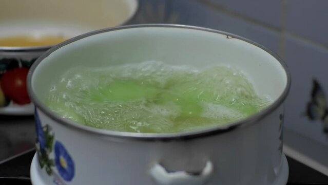Chayote squash is blanched in a small pot of boiling water for dessert