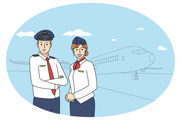 Happy pilot and stewardess near airplane