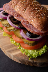 photo layered sandwich with salami and vegetables