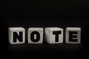 Obraz premium Word NOTE written with wooden cubes. Studio shot of some arranged wooden blocks with a testual message about disinformation.