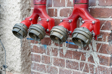 Fire hydrant for a quick set of water on a brick wall.