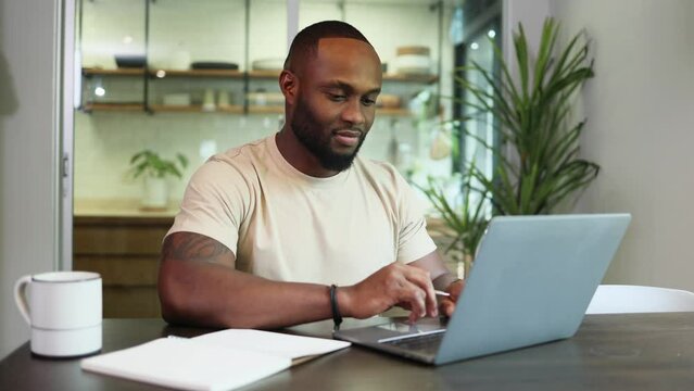 Young business black african american man working from home on table with notebook computer laptop
