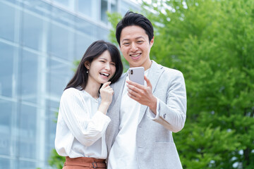 携帯を見るミドル日本人カップル