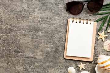 Blank writing book with summer beach accessories on background, copy space. Flat lay with copy space