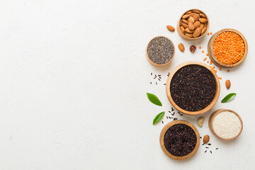 Various superfoods in smal bowl on colored background. Superfood as rice, chia, quinoa, lentils, nuts, sesame seeds, almonds. top view copy space