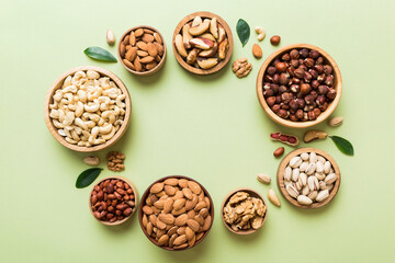 mixed nuts in wooden bowl. Mix of various nuts on colored background. pistachios, cashews, walnuts, hazelnuts, peanuts and brazil nuts