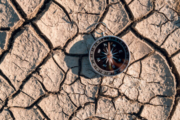 Compass and navigation background on dry soil, top-view