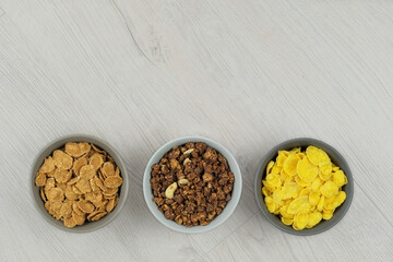 Breakfast cereals in bowls on a light wooden background. Fast food. Top view. Space for text.